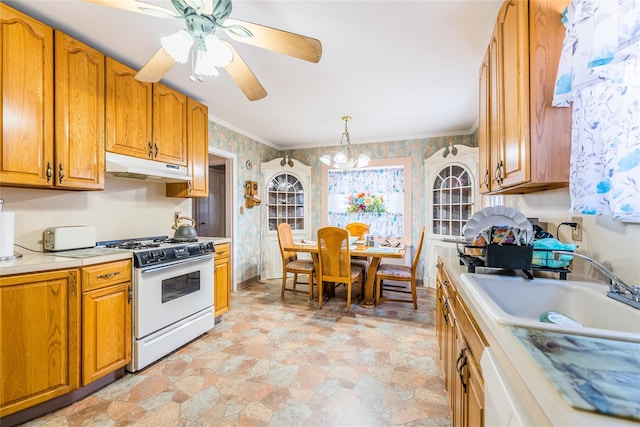 kitchen featuring under cabinet range hood, white range with gas stovetop, wallpapered walls, light countertops, and light stone finish flooring