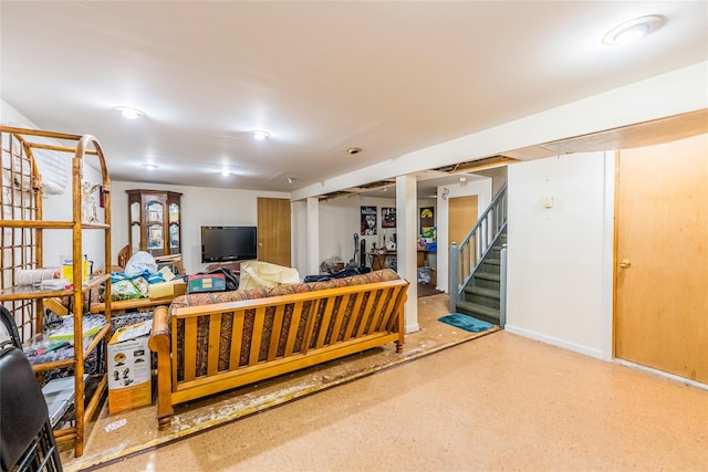 living area featuring stairway and baseboards