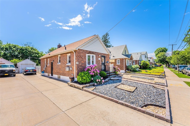 view of front of home featuring a garage, brick siding, an outdoor structure, a chimney, and a residential view