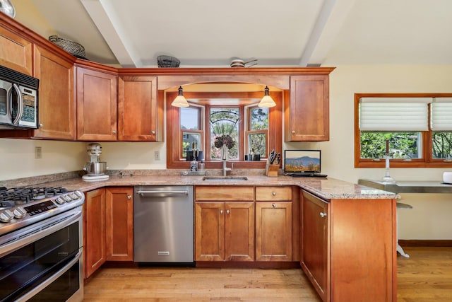 1 Meadowood Path, New Rochelle, NY 10804 - kitchen with stainless steel appliances, a sink, light wood-type flooring, light stone counters, and brown cabinetry