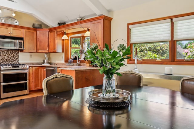 1 Meadowood Path, New Rochelle, NY 10804 - kitchen featuring stainless steel appliances, brown cabinets, lofted ceiling, and a sink