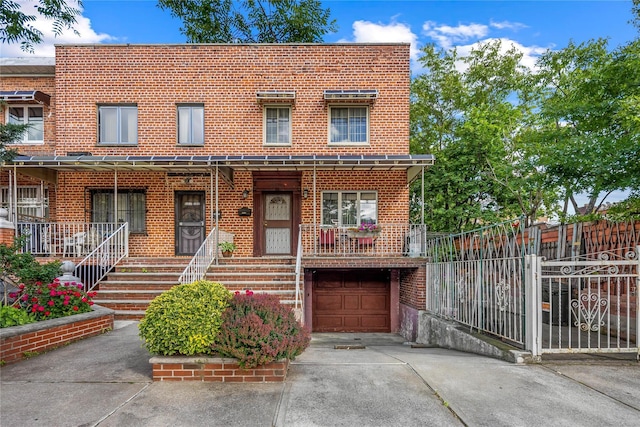 17-12 Starr St, Ridgewood, NY 11385 - townhome / multi-family property featuring concrete driveway, brick siding, a garage, and a porch