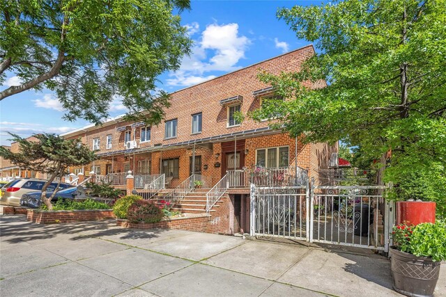 17-12 Starr St, Ridgewood, NY 11385 - view of front facade featuring brick siding and a porch
