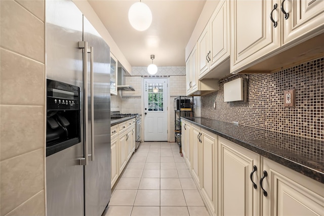 17-12 Starr St, Ridgewood, NY 11385 - kitchen featuring stainless steel appliances, cream cabinets, light tile patterned floors, backsplash, and wall chimney exhaust hood
