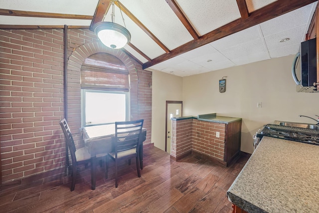 70-27 69th St, Glendale, NY 11385 - dining space featuring dark wood-type flooring and brick wall
