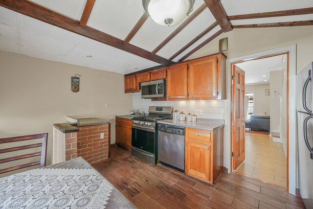 70-27 69th St, Glendale, NY 11385 - kitchen featuring stainless steel appliances, dark wood finished floors, backsplash, brown cabinetry, and recessed lighting