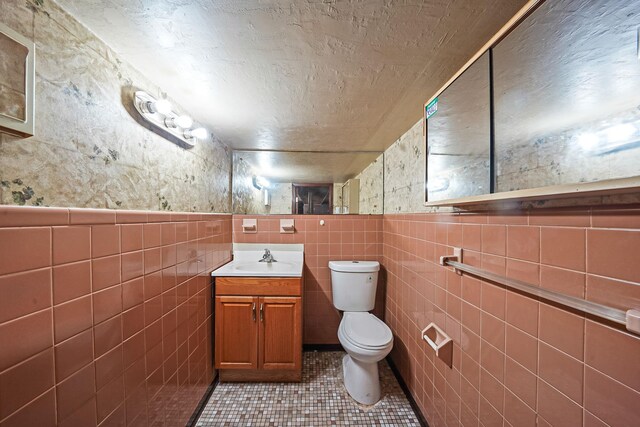 70-27 69th St, Glendale, NY 11385 - bathroom with tile walls, toilet, tile patterned flooring, and vanity