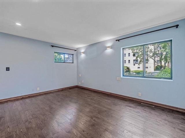 10 Wooleys Ln Unit 1F, Great Neck, NY 11023 - empty room featuring healthy amount of natural light, wood finished floors, and baseboards