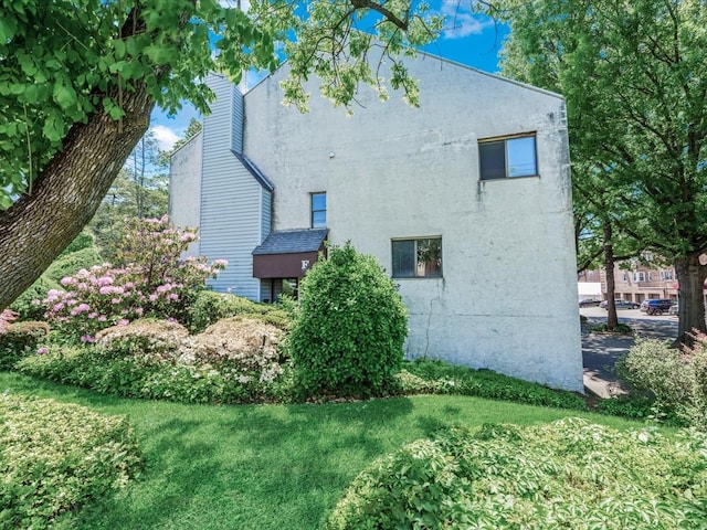 10 Wooleys Ln Unit 1F, Great Neck, NY 11023 - view of side of home with a lawn and a chimney