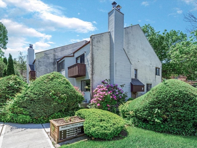 10 Wooleys Ln Unit 1F, Great Neck, NY 11023 - view of side of property featuring a chimney and a balcony