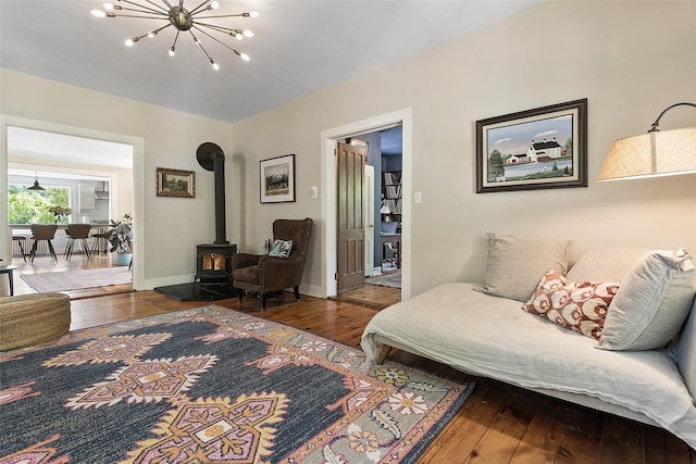 679 Titicus Rd, North Salem, NY 10560 - living room featuring hardwood / wood-style floors, a wood stove, a chandelier, and baseboards