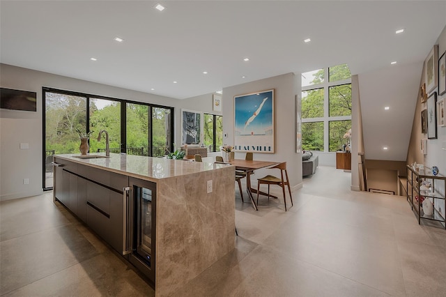 7 Robin Ln, Shelter Island Heights, NY 11964 - kitchen featuring modern cabinets, a sink, a kitchen island with sink, light stone counters, and recessed lighting