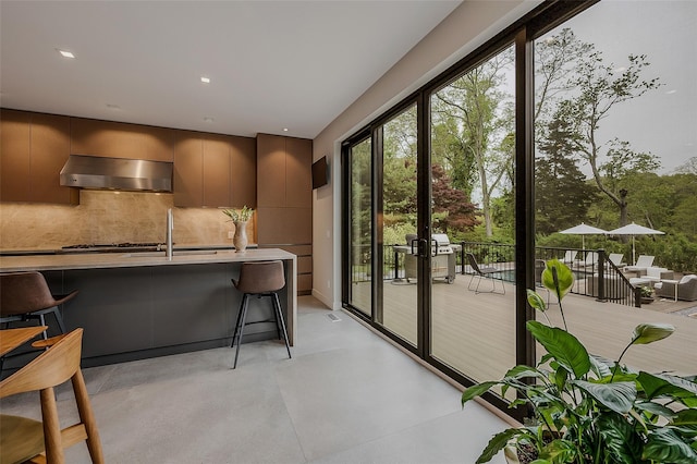 7 Robin Ln, Shelter Island Heights, NY 11964 - kitchen with wall chimney exhaust hood, modern cabinets, backsplash, and a sink