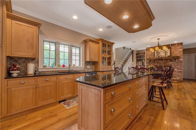 32 Old Chester Rd, Goshen, NY 10924 - kitchen with light wood-type flooring, a center island, a sink, crown molding, and dark stone countertops