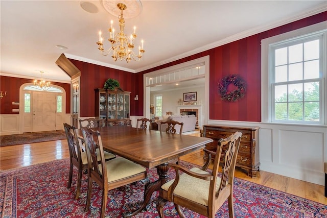 32 Old Chester Rd, Goshen, NY 10924 - dining room featuring a chandelier, ornamental molding, a decorative wall, wood finished floors, and a fireplace