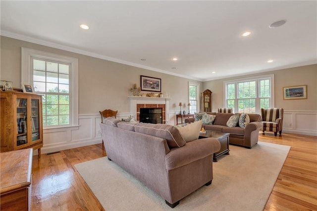 32 Old Chester Rd, Goshen, NY 10924 - living room featuring light wood-type flooring, ornamental molding, a decorative wall, a brick fireplace, and wainscoting