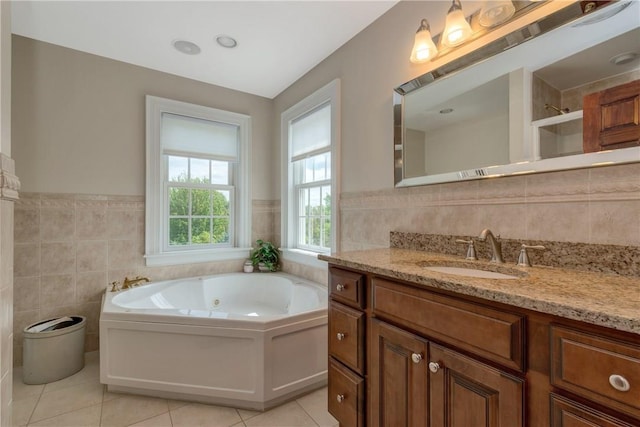 32 Old Chester Rd, Goshen, NY 10924 - bathroom with tile walls, tile patterned floors, vanity, a jetted tub, and a wainscoted wall