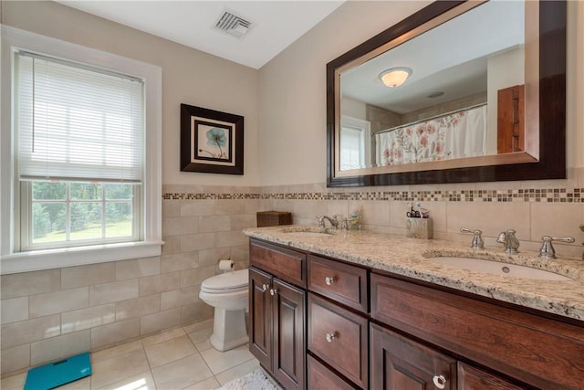 32 Old Chester Rd, Goshen, NY 10924 - bathroom with tile walls, tile patterned floors, toilet, double vanity, and wainscoting