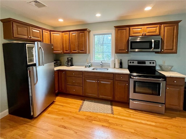 32 Old Chester Rd, Goshen, NY 10924 - kitchen with appliances with stainless steel finishes, a sink, light countertops, brown cabinetry, and recessed lighting