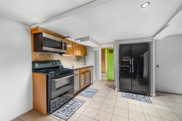 13538 129th St, South Ozone Park, NY 11420 - kitchen featuring black appliances, backsplash, light tile patterned floors, and a sink