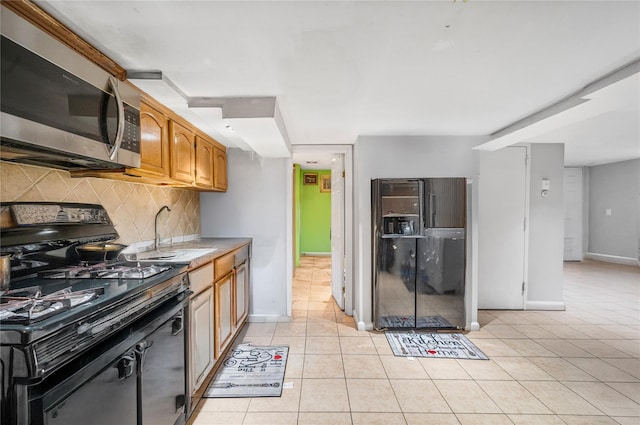 13538 129th St, South Ozone Park, NY 11420 - kitchen featuring black appliances, a sink, tasteful backsplash, light tile patterned floors, and light countertops