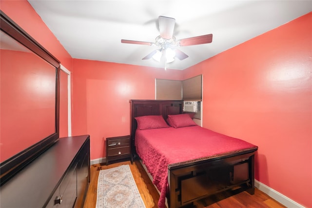 13538 129th St, South Ozone Park, NY 11420 - bedroom with wood finished floors, baseboards, ceiling fan, and cooling unit