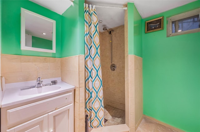 13538 129th St, South Ozone Park, NY 11420 - full bathroom featuring tile walls, tiled shower, vanity, and a wainscoted wall