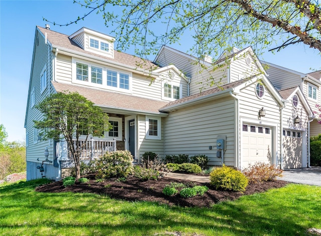 68 Hudson View Ter, Hyde Park, NY 12538 - traditional-style home with covered porch, a front yard, an attached garage, asphalt driveway, and roof with shingles