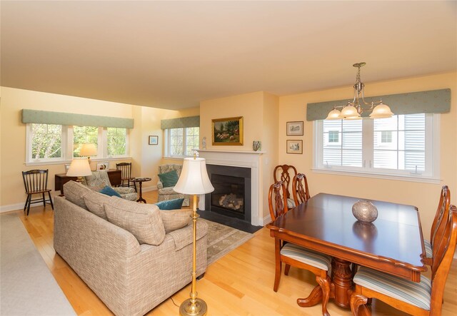 68 Hudson View Ter, Hyde Park, NY 12538 - living area featuring light wood-style flooring, a fireplace with flush hearth, a chandelier, and baseboards