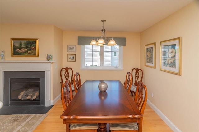 68 Hudson View Ter, Hyde Park, NY 12538 - dining room with wood finished floors, a chandelier, baseboards, and a fireplace with flush hearth