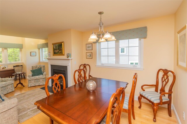 68 Hudson View Ter, Hyde Park, NY 12538 - dining room with light wood-type flooring, a fireplace, and a chandelier