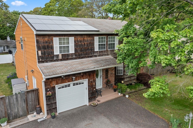 60 Heston Rd, Shirley, NY 11967 - view of front facade featuring an attached garage, solar panels, driveway, and roof with shingles