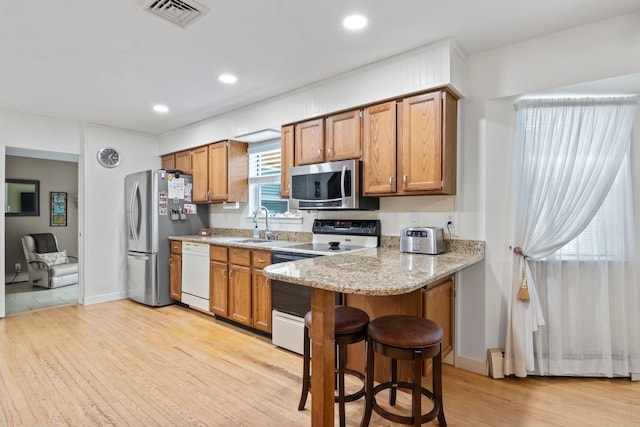 60 Heston Rd, Shirley, NY 11967 - kitchen with stainless steel appliances, light wood finished floors, brown cabinets, a sink, and recessed lighting