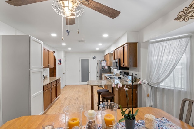 60 Heston Rd, Shirley, NY 11967 - kitchen featuring ceiling fan, light wood-type flooring, recessed lighting, brown cabinets, and a peninsula