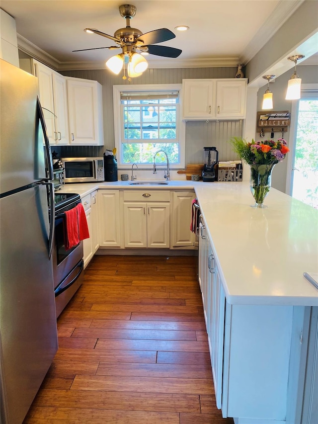 24 Lowerre St, Babylon, NY 11702 - kitchen featuring appliances with stainless steel finishes, a ceiling fan, a sink, crown molding, and white cabinetry