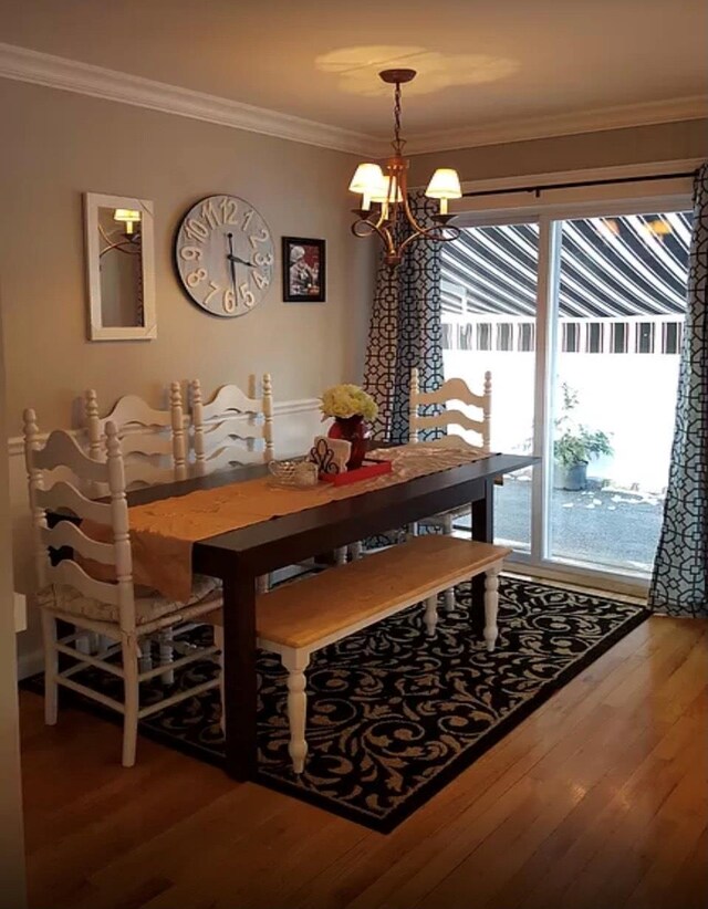24 Lowerre St, Babylon, NY 11702 - dining space featuring wood finished floors, a chandelier, and crown molding
