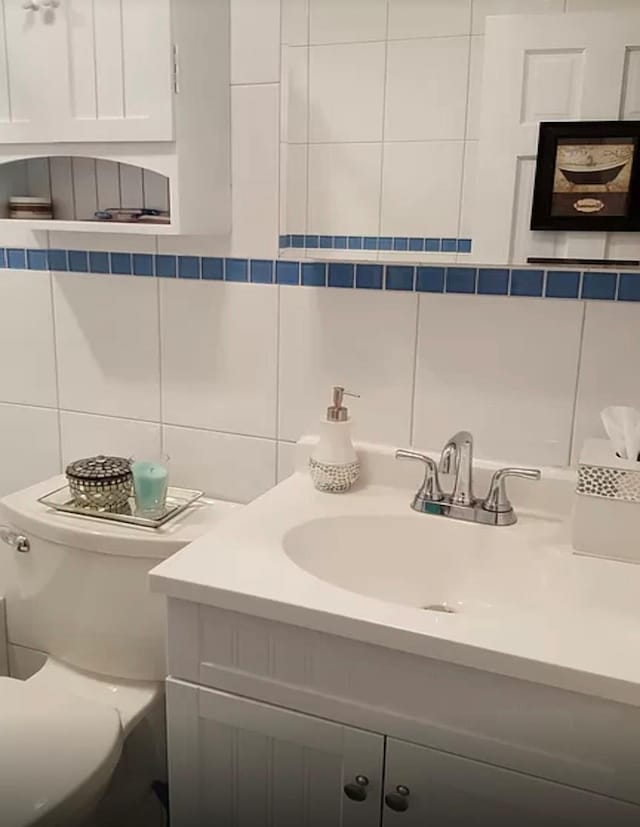24 Lowerre St, Babylon, NY 11702 - half bath featuring vanity, backsplash, toilet, and tile walls