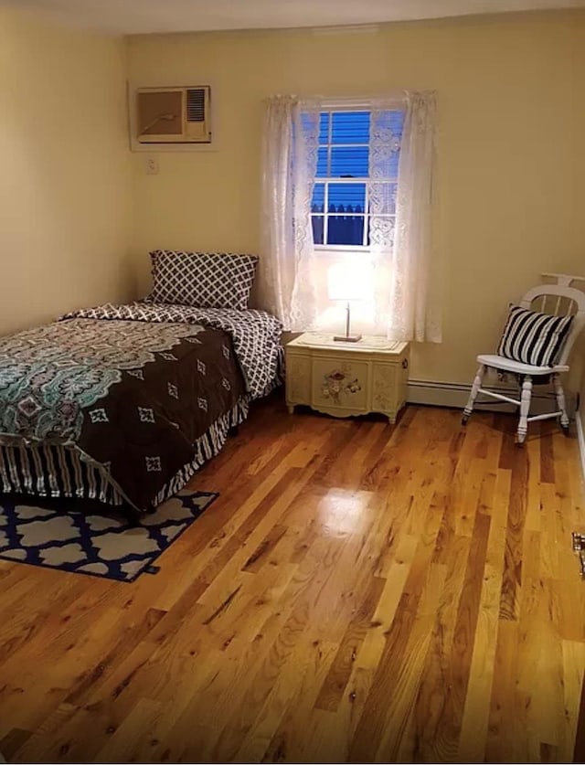 24 Lowerre St, Babylon, NY 11702 - bedroom featuring wood finished floors and a wall unit AC