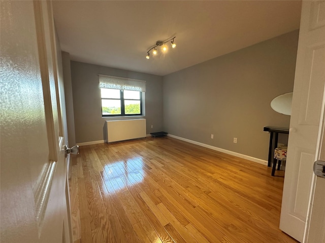 87-30 62nd Ave Unit 5-E, Rego Park, NY 11374 - spare room featuring light wood finished floors, radiator, and baseboards