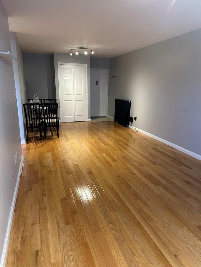 87-30 62nd Ave Unit 5-E, Rego Park, NY 11374 - living area featuring wood-type flooring, baseboards, and rail lighting