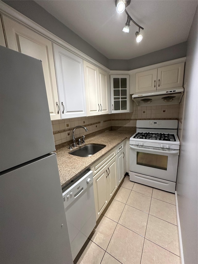 87-30 62nd Ave Unit 5-E, Rego Park, NY 11374 - kitchen featuring white appliances, a sink, under cabinet range hood, white cabinets, and tasteful backsplash