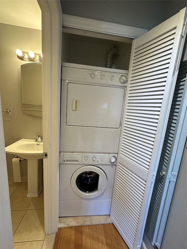 87-30 62nd Ave Unit 5-E, Rego Park, NY 11374 - laundry area with stacked washer and clothes dryer and tile patterned flooring