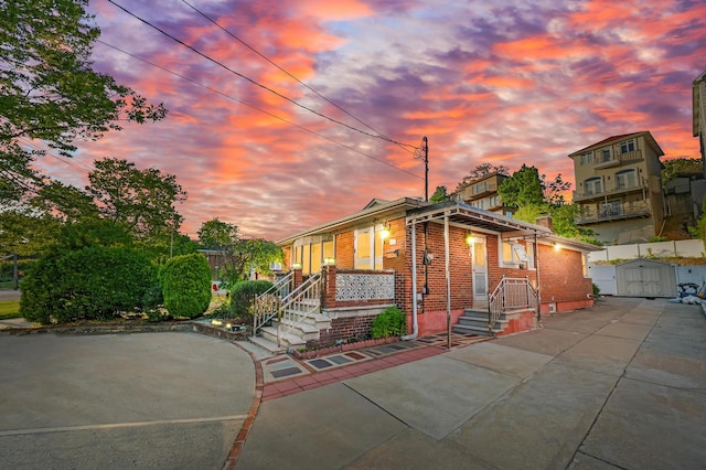 669 W Fingerboard Rd, Staten Island, NY 10305 - view of front facade featuring brick siding, a chimney, and a storage shed