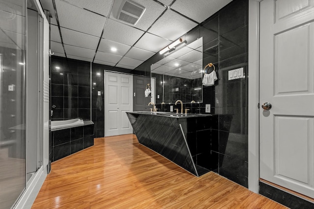 669 W Fingerboard Rd, Staten Island, NY 10305 - bathroom with double vanity, a bath, wood finished floors, and an enclosed shower
