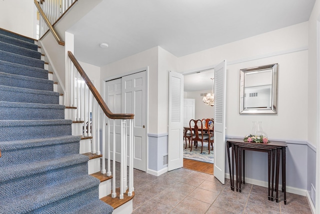 10 Catherine Pl, Katonah, NY 10536 - staircase featuring a chandelier, tile patterned flooring, and baseboards