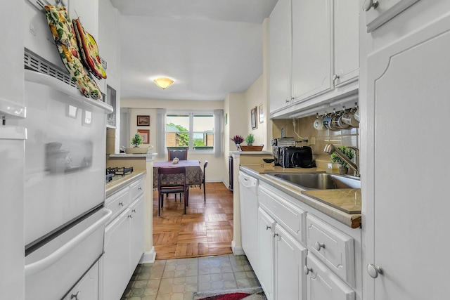 6636 Yellowstone Blvd # 6E, Forest Hills, NY 11375 - kitchen featuring a sink, a warming drawer, light countertops, white cabinets, and tasteful backsplash