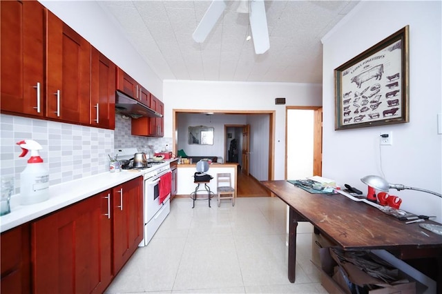 kitchen with white gas range oven, under cabinet range hood, decorative backsplash, light countertops, and ceiling fan