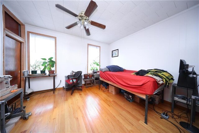 bedroom with hardwood / wood-style floors and a ceiling fan