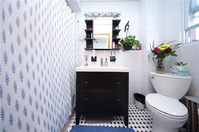 bathroom featuring toilet, vanity, tile walls, and curtained shower