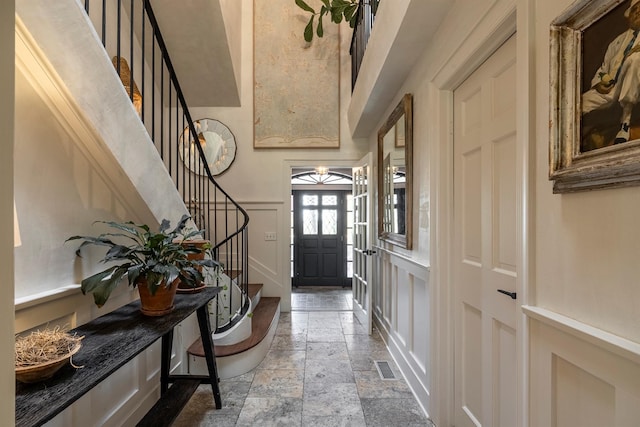 8 Lost Pond Ln, North Salem, NY 10560 - entrance foyer featuring a decorative wall, stone tile flooring, and stairs